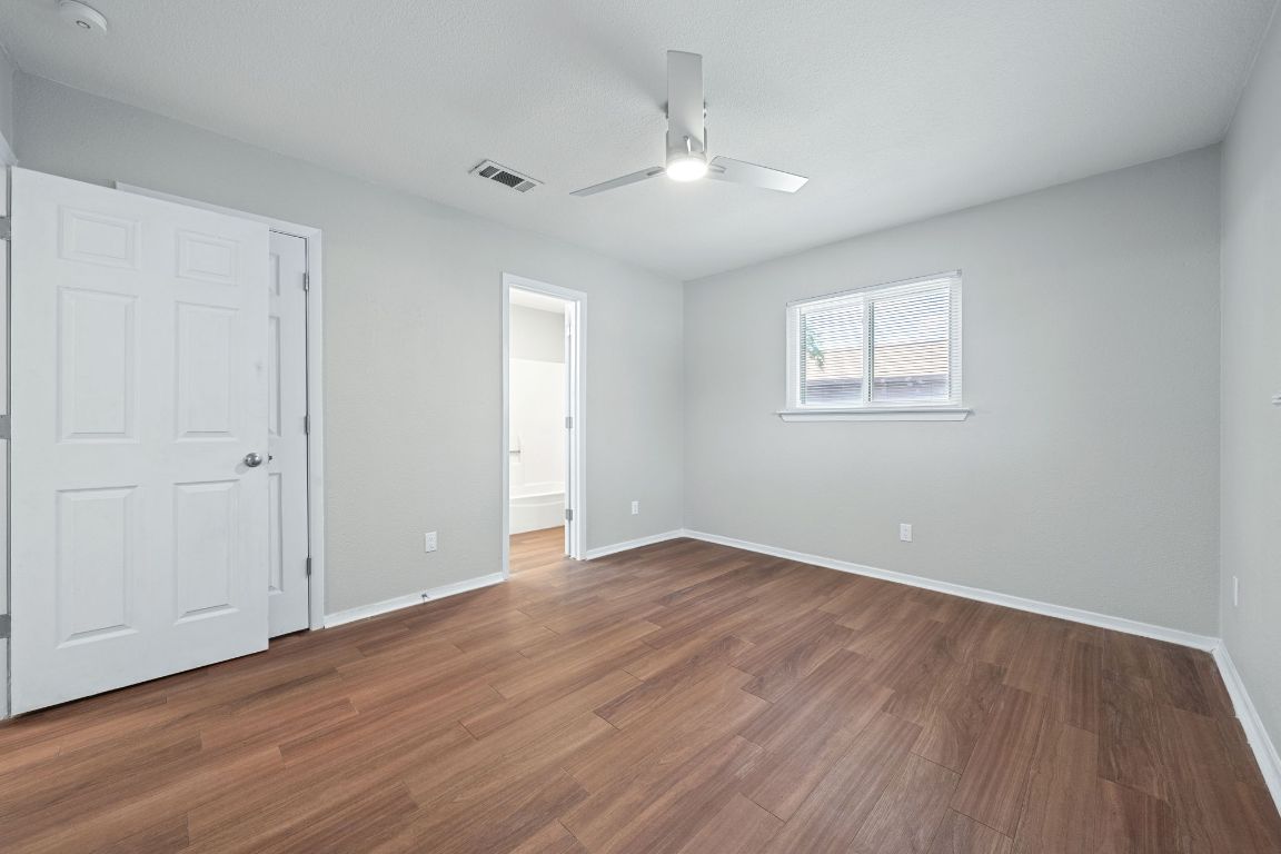 1810 Mearns Meadow Boulevard, Unit B Austin, TX 78758 - Photo 18 of 21 an empty room with wooden floor chandelier and windows