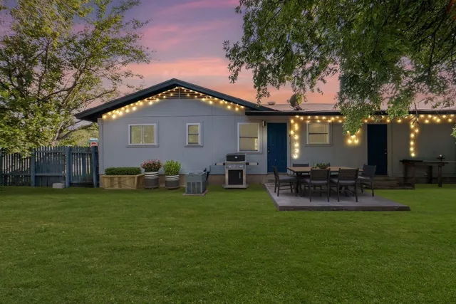 a backyard of a house with table and chairs
