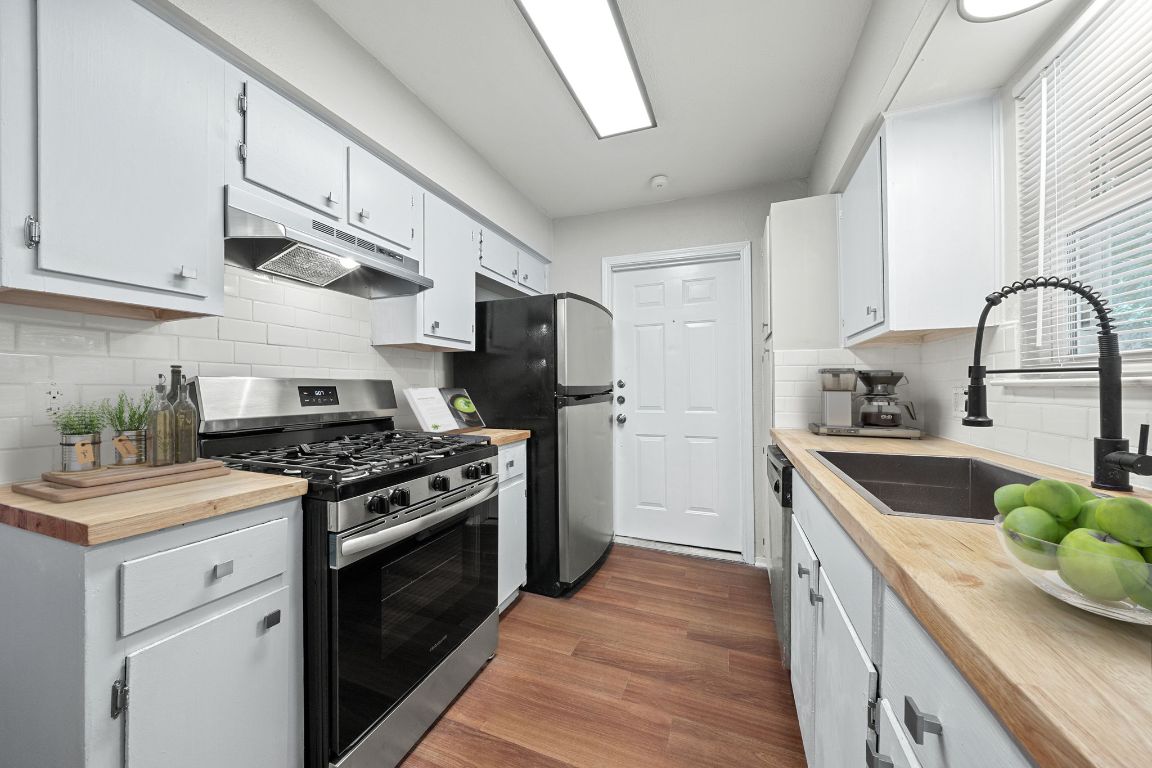 1810 Mearns Meadow Boulevard, Unit B Austin, TX 78758 - Photo 4 of 21 a kitchen with stainless steel appliances granite countertop a stove a sink dishwasher and a refrigerator