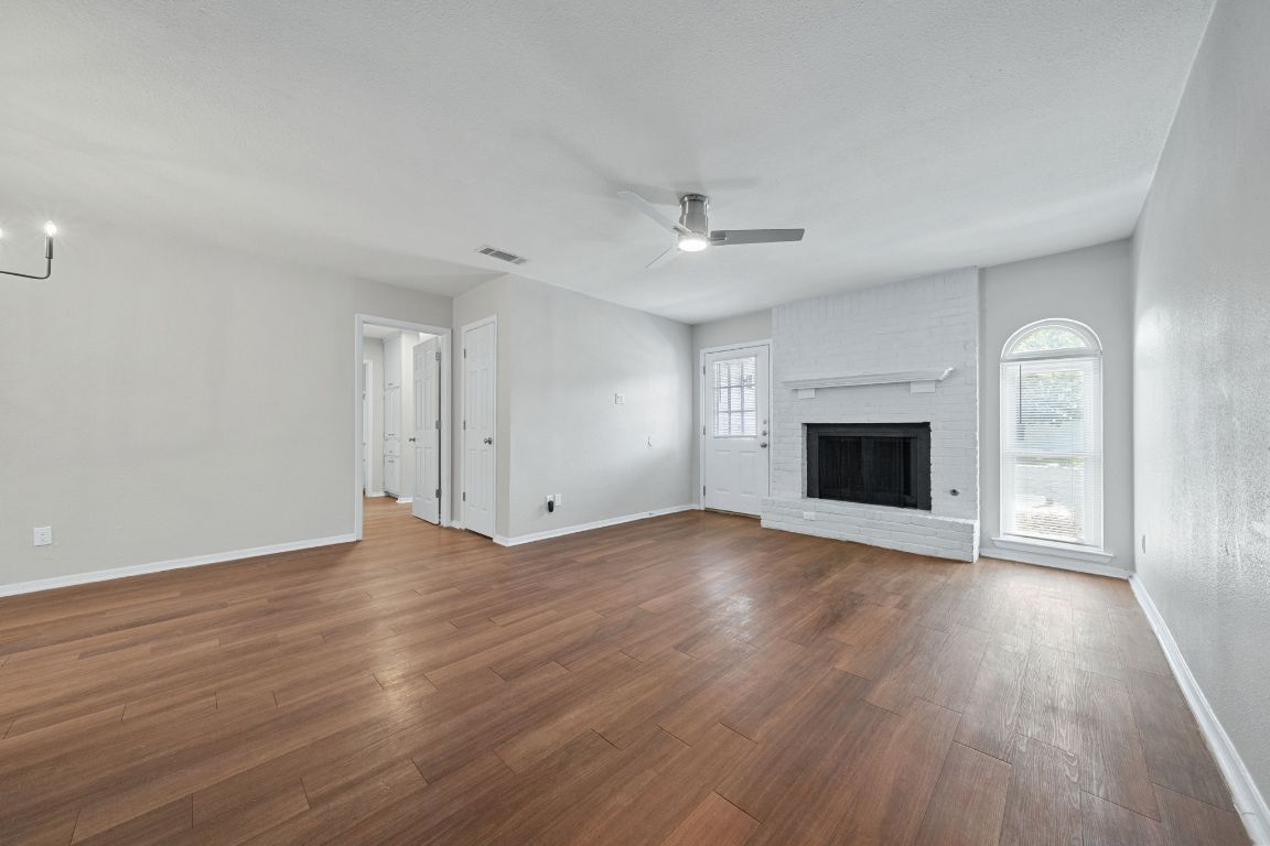 1810 Mearns Meadow Boulevard, Unit B Austin, TX 78758 - Photo 6 of 21 an empty room with wooden floor fireplace and windows