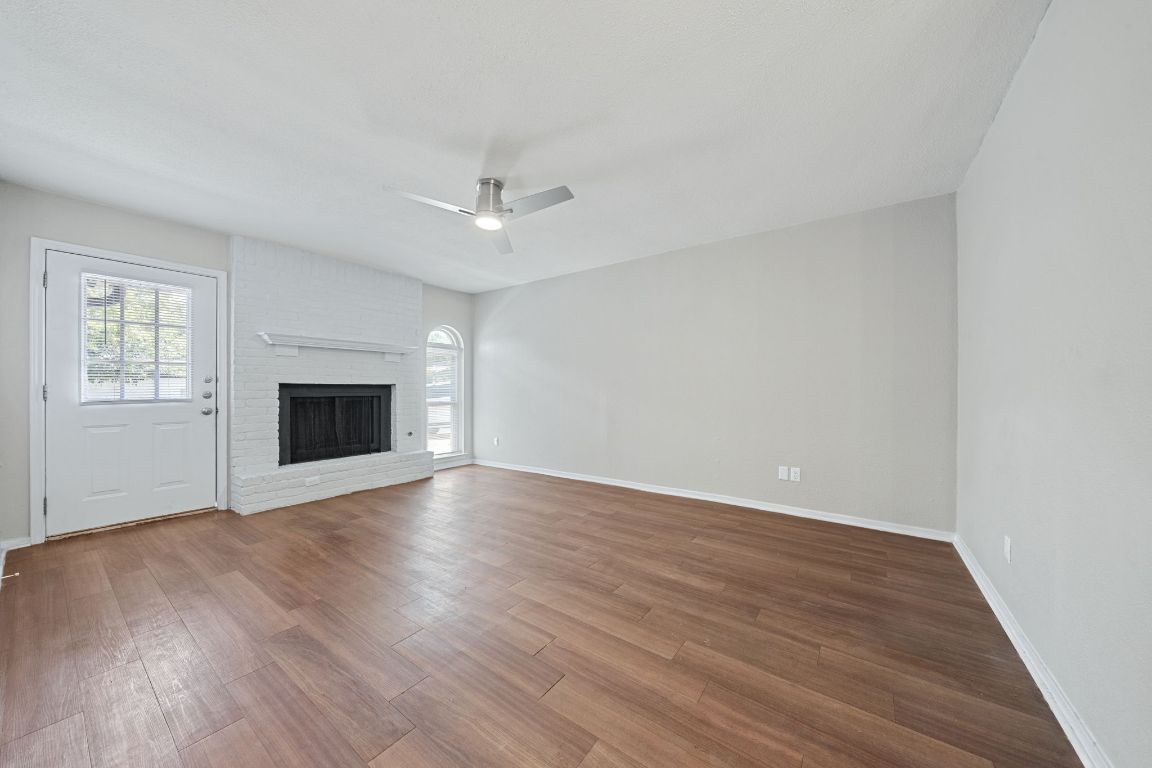 1810 Mearns Meadow Boulevard, Unit B Austin, TX 78758 - Photo 7 of 21 an empty room with wooden floor fireplace and windows
