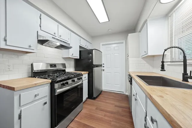 a view of kitchen with sink microwave and refrigerator