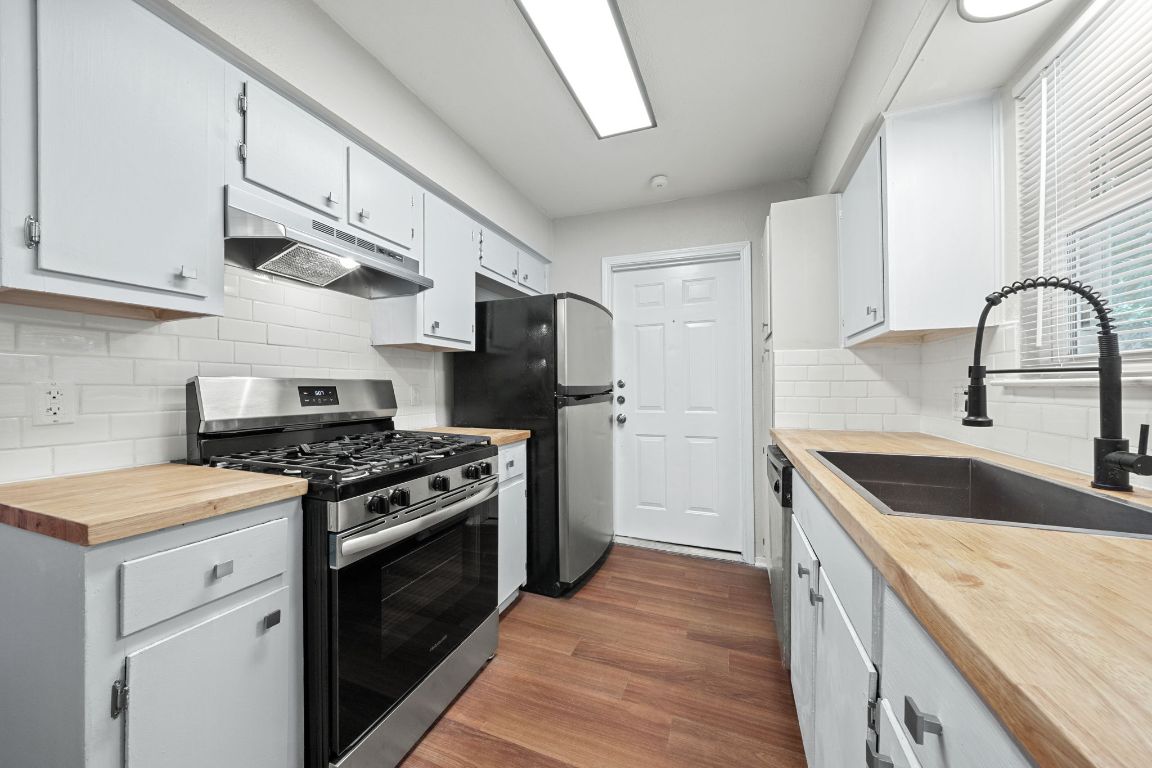 1810 Mearns Meadow Boulevard, Unit B Austin, TX 78758 - Photo 9 of 21 a kitchen with stainless steel appliances granite countertop a sink stove and refrigerator