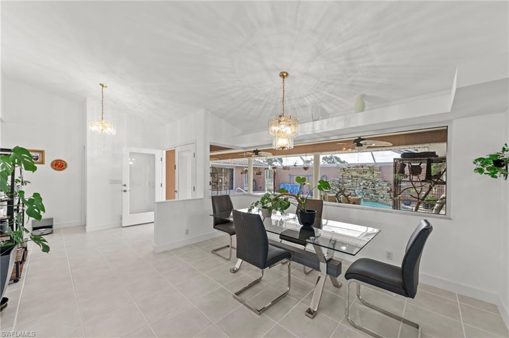 13541 Stringfellow Road Bokeelia, FL 33922 - Photo 11 of 49 a dining room with furniture a chandelier and wooden floor