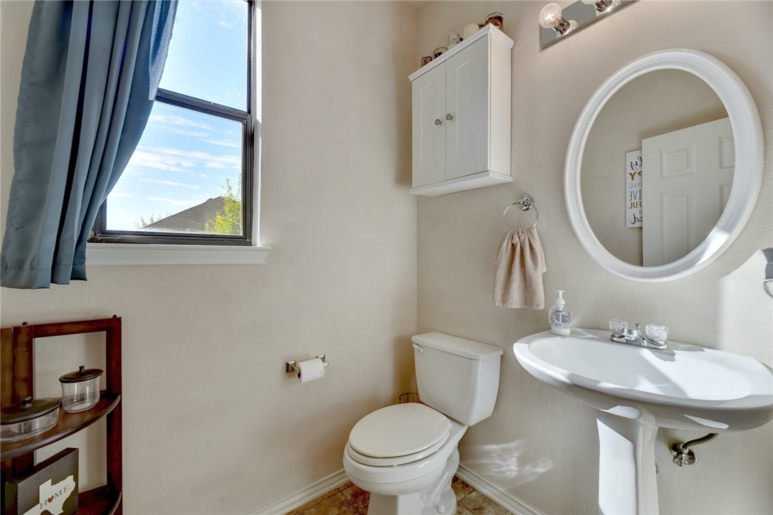 145 Rudy Lane Kyle, TX 78640 - Photo 17 of 29 a bathroom with a toilet a sink and a mirror