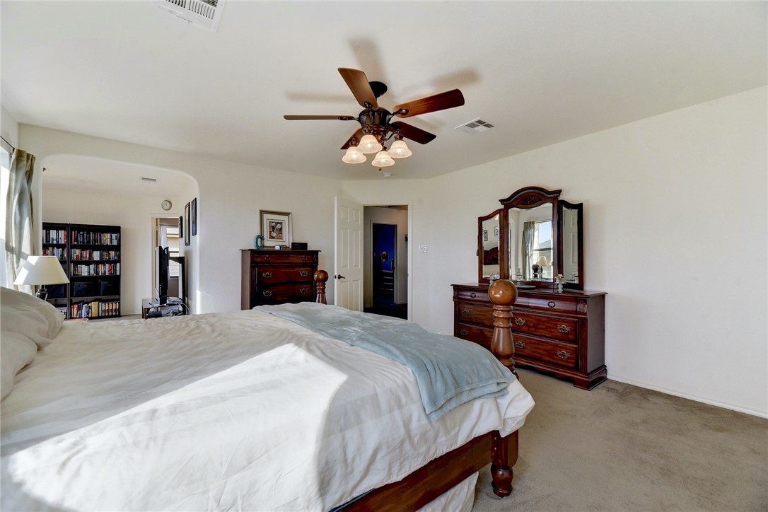 145 Rudy Lane Kyle, TX 78640 - Photo 21 of 29 a bedroom with a bed and wooden floor