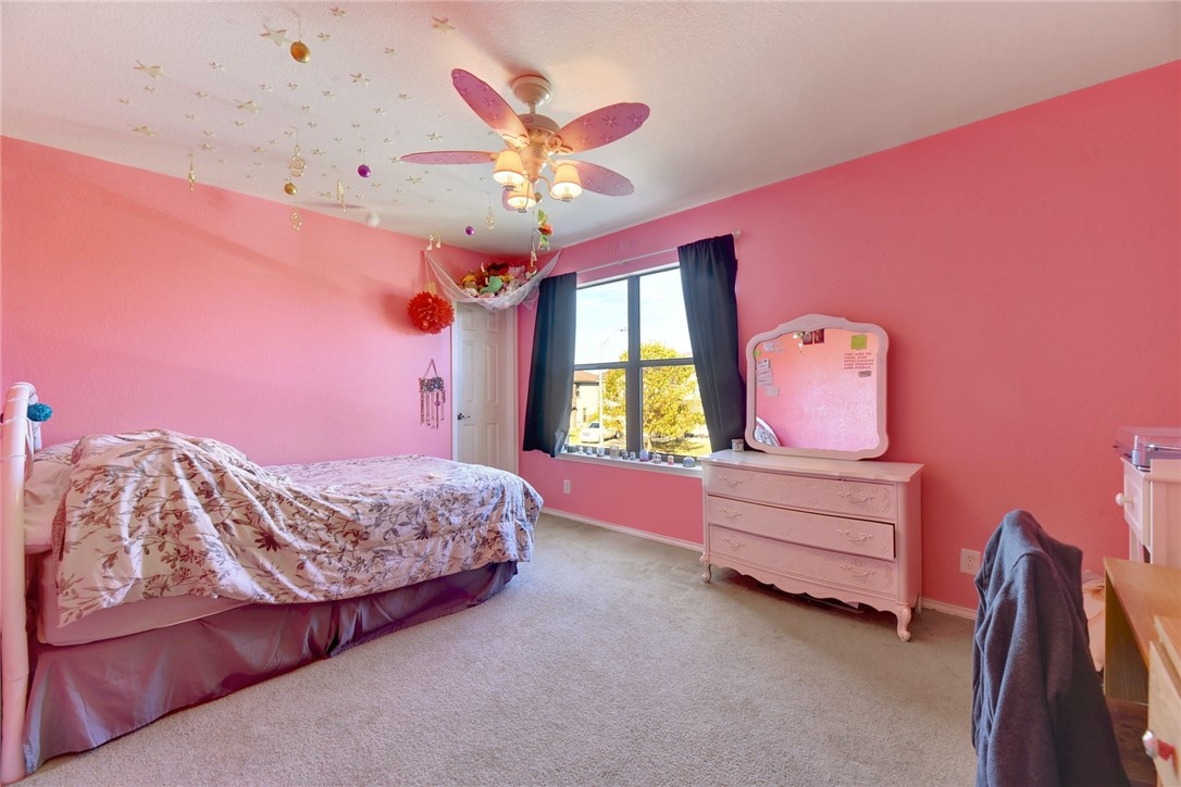 145 Rudy Lane Kyle, TX 78640 - Photo 23 of 29 a bedroom with a bed and a chandelier