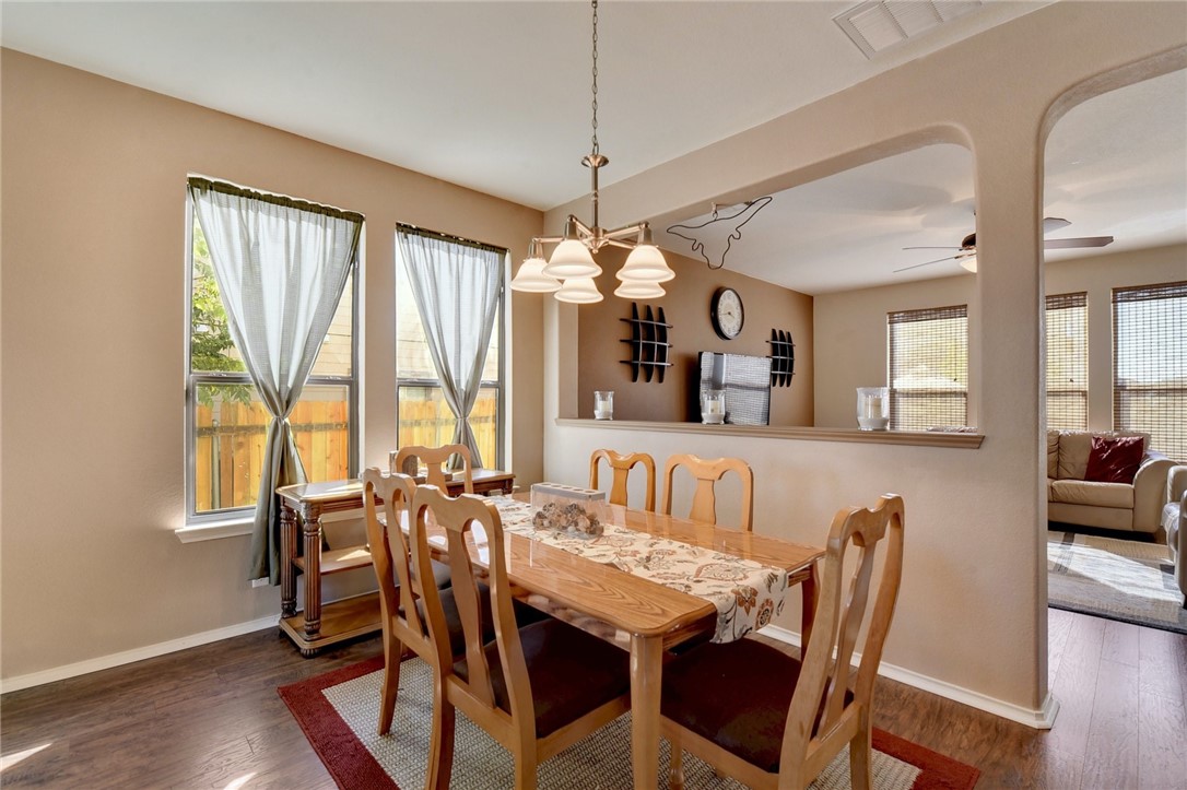 145 Rudy Lane Kyle, TX 78640 - Photo 6 of 29 a view of a dining room with furniture large windows and wooden floor