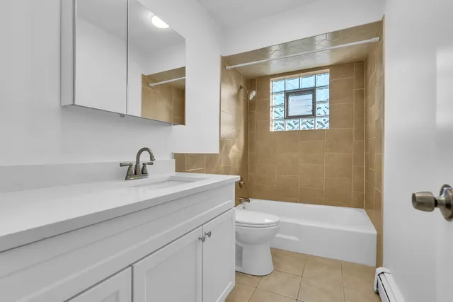 a bathroom with a granite countertop sink a toilet and bathtub