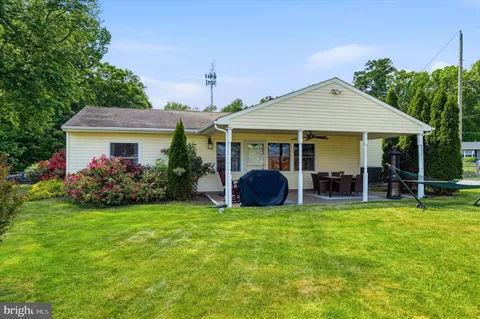 a view of a house with a yard and sitting area