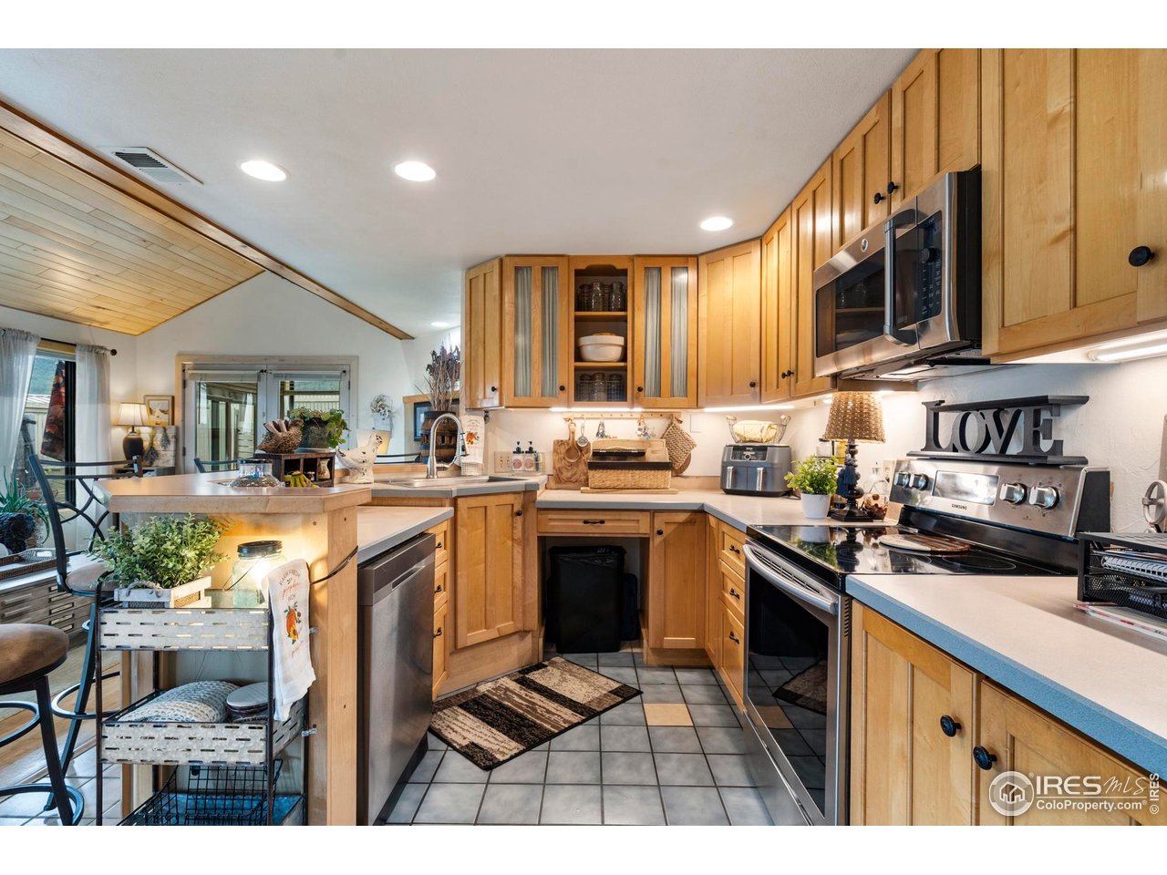 123 Mohawk Road Lyons, CO 80540 - Photo 11 of 38 a kitchen with stainless steel appliances granite countertop a stove a sink dishwasher and a microwave oven with white cabinets