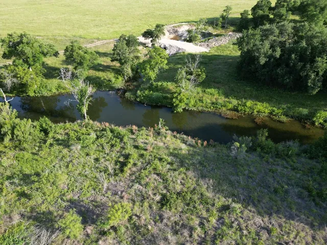 an aerial view of ocean with green space