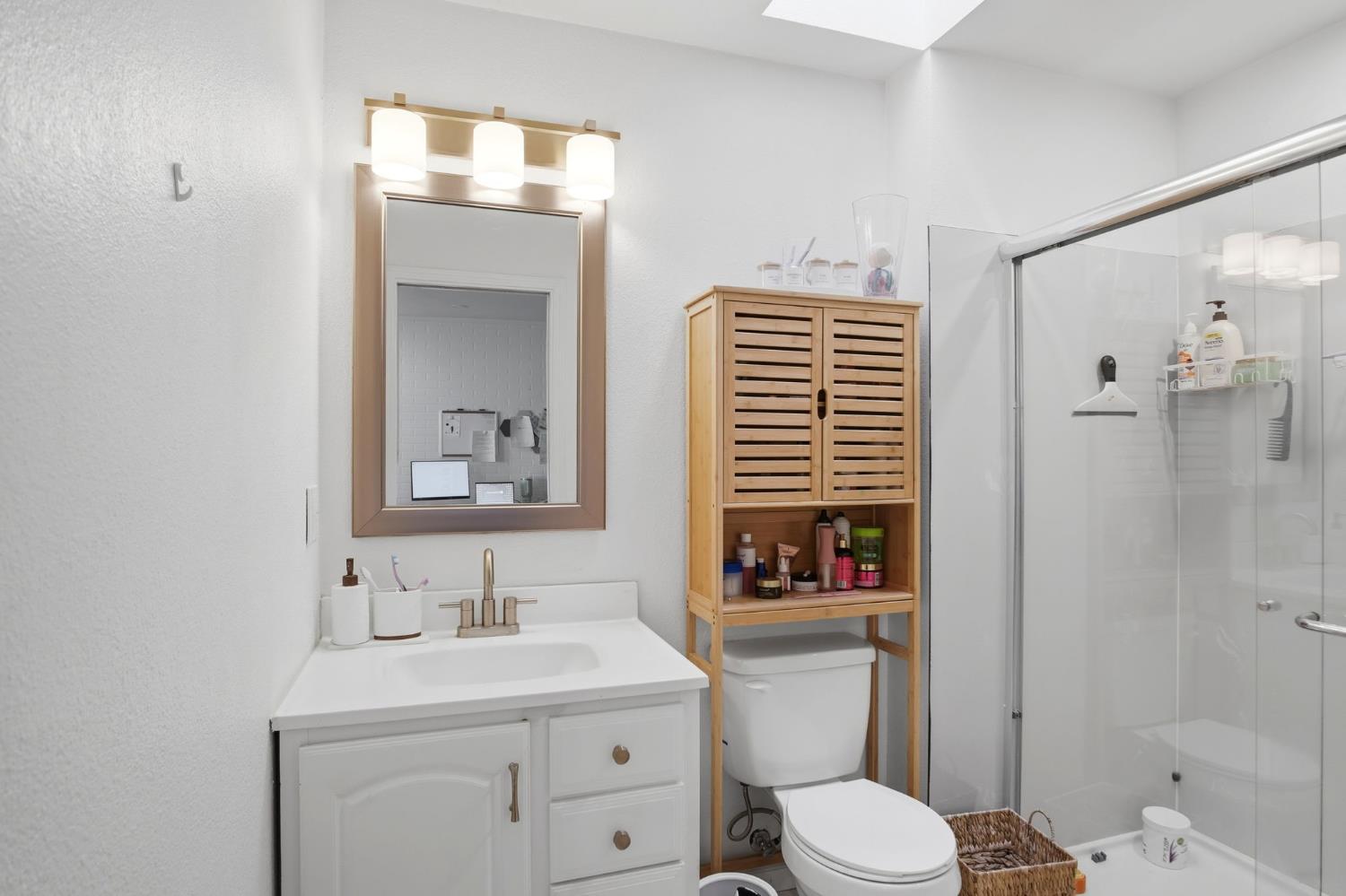 680 Sherri Way Turlock, CA 95382 - Photo 13 of 24 a bathroom with a toilet a sink a mirror a shower a vanity and window