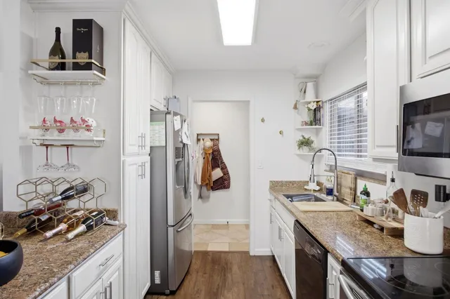 a kitchen with stainless steel appliances granite countertop a refrigerator and a stove top oven