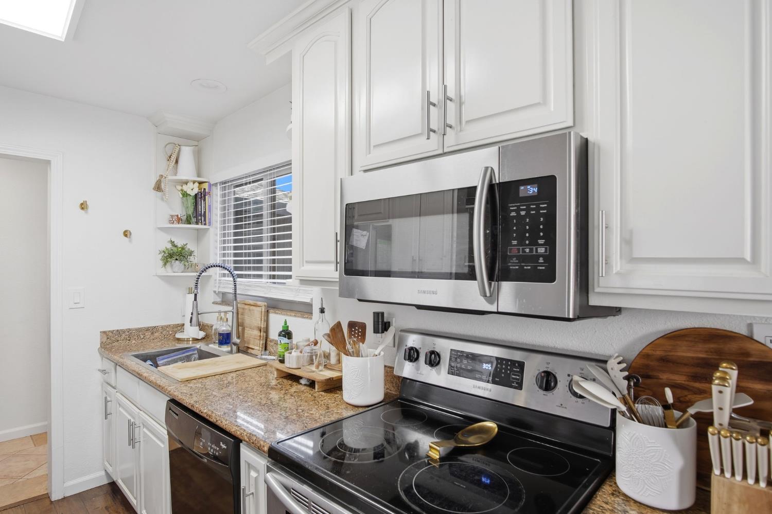 680 Sherri Way Turlock, CA 95382 - Photo 18 of 24 a kitchen with stainless steel appliances granite countertop a stove and a microwave
