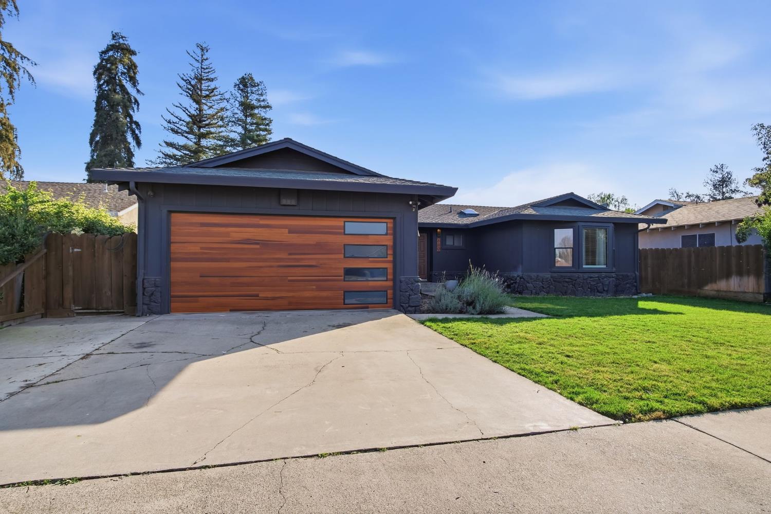 680 Sherri Way Turlock, CA 95382 - Photo 2 of 24 a front view of a house with a yard and garage