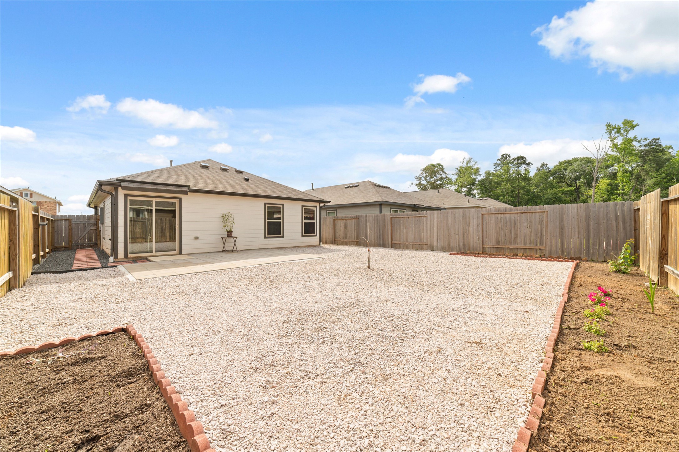 14232 Shasta Ridge Drive Conroe, TX 77303 - Photo 25 of 26 Expansive backyard with low-maintenance gravel and defined garden beds, ready for your personal touch.