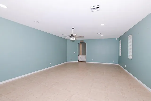 a view of an empty room with a chandelier fan