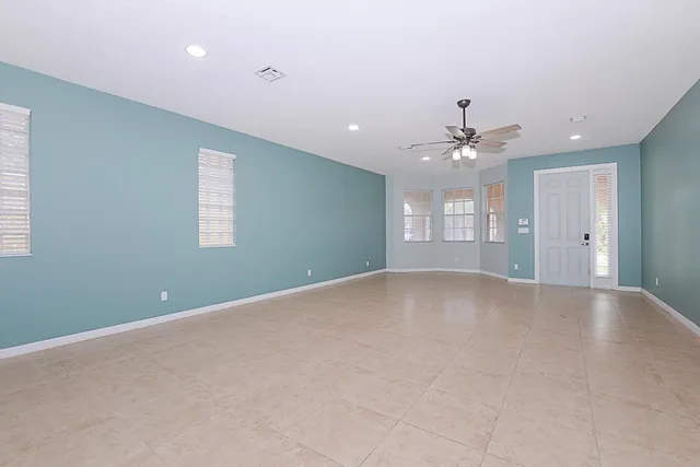 a view of a livingroom with a chandelier fan and windows