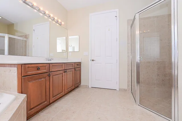 a bathroom with a granite countertop sink mirror and a shower