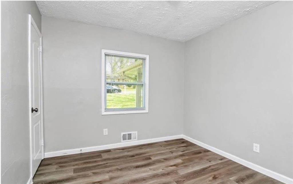 3711 Daisy Drive Decatur, GA 30032 - Photo 14 of 18 a view of an empty room with wooden floor and a window