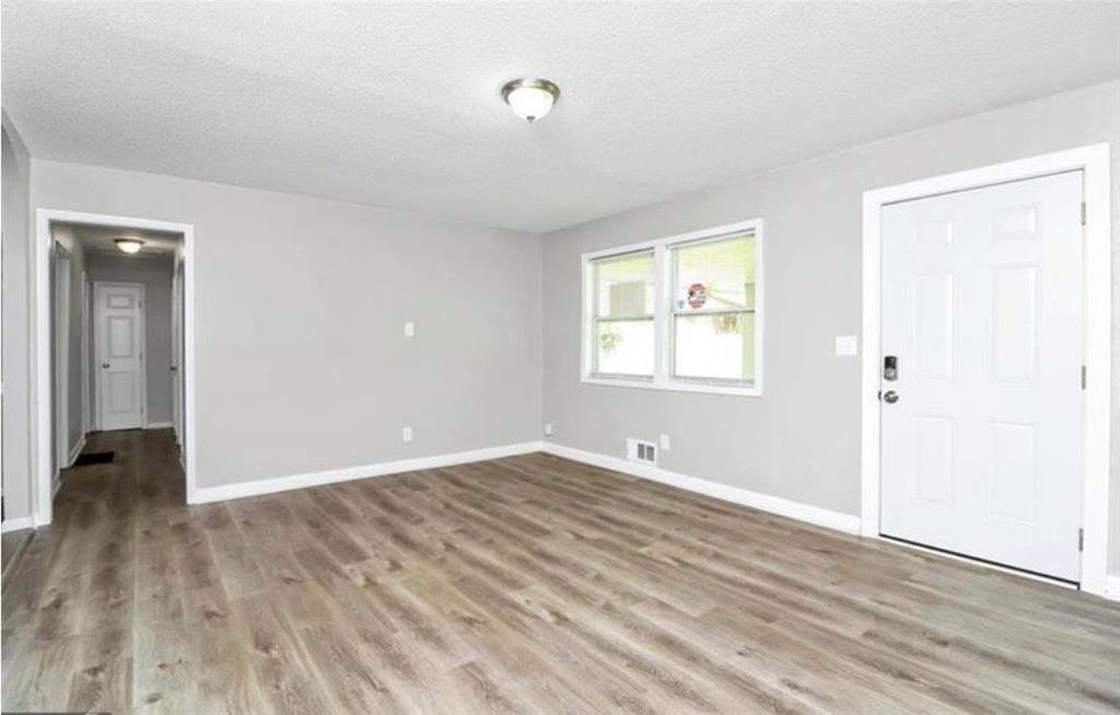 3711 Daisy Drive Decatur, GA 30032 - Photo 3 of 18 a view of an empty room with wooden floor and a window