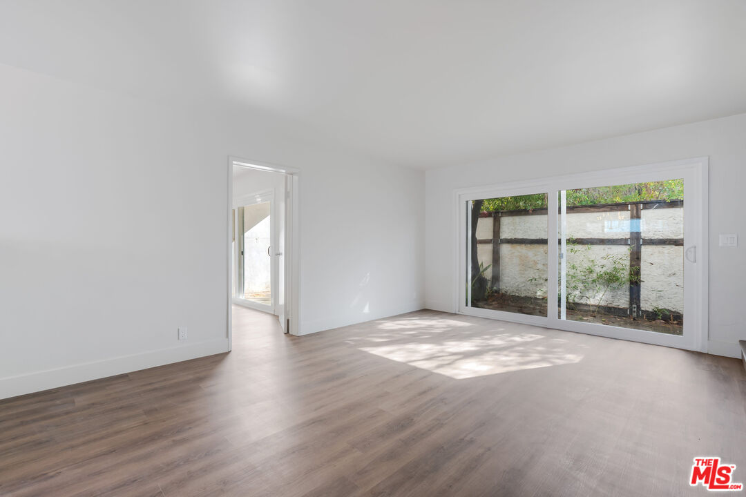 1813 9th Street, Unit 4 Santa Monica, CA 90404 - Photo 3 of 15 a view of an empty room with a window and wooden floor