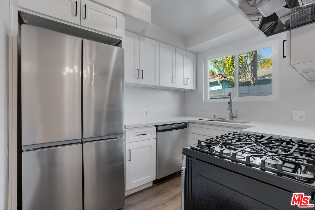 1813 9th Street, Unit 4 Santa Monica, CA 90404 - Photo 5 of 15 a kitchen with stainless steel appliances granite countertop a refrigerator and a stove