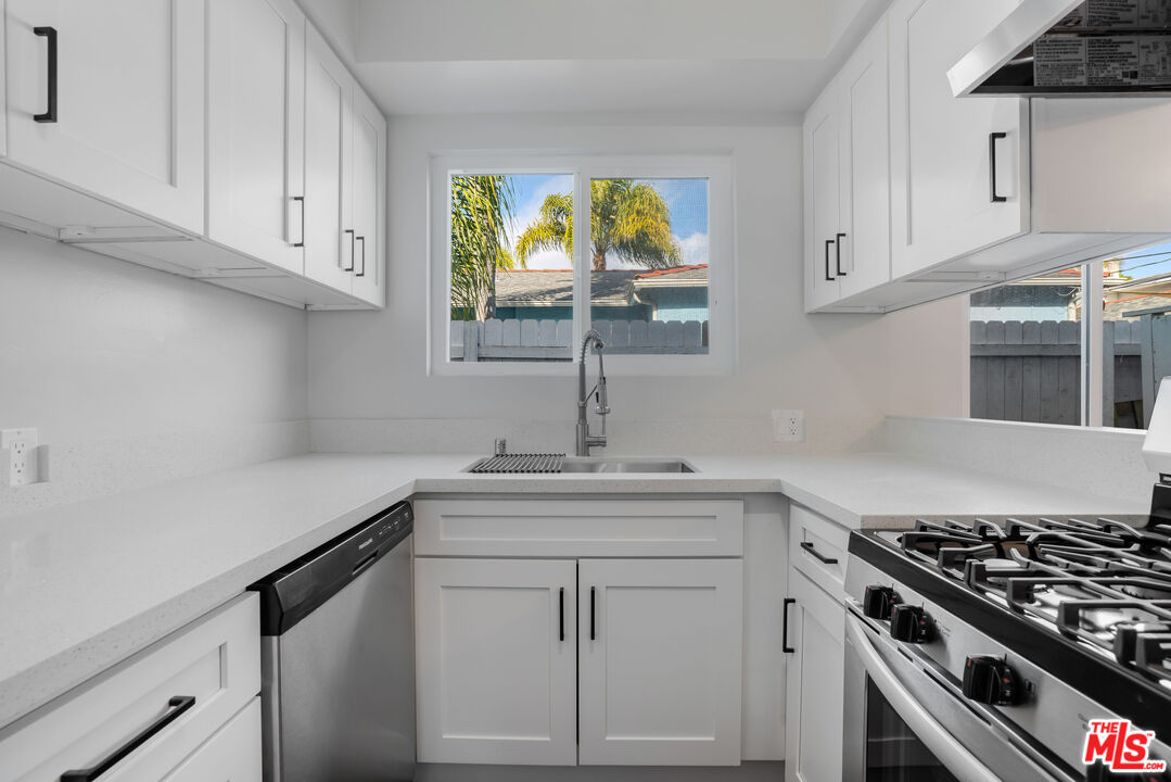 1813 9th Street, Unit 4 Santa Monica, CA 90404 - Photo 6 of 15 a kitchen with white cabinets and appliances
