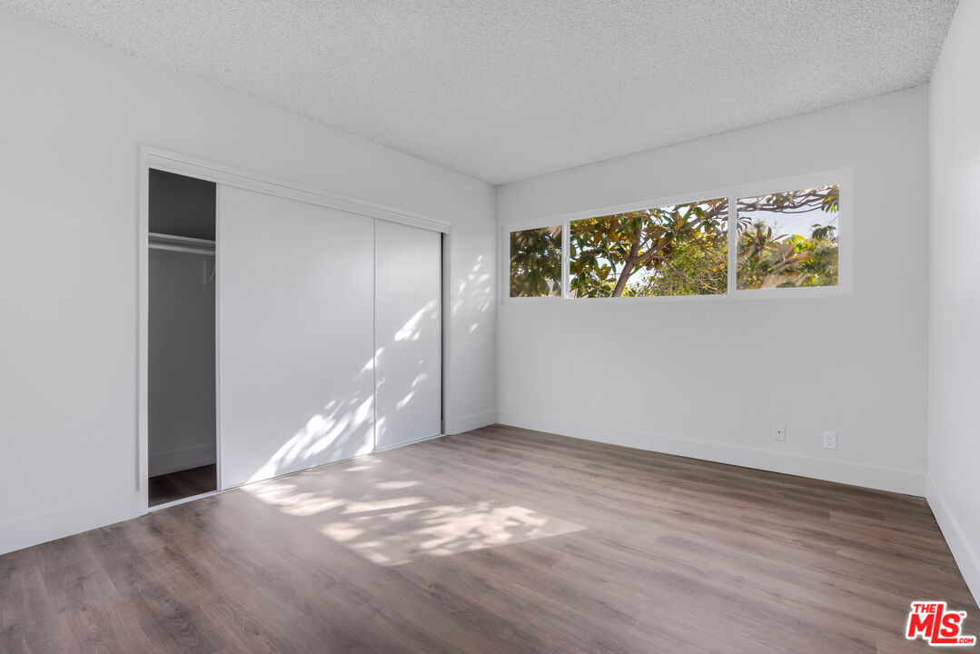1813 9th Street, Unit 4 Santa Monica, CA 90404 - Photo 9 of 15 a view of an empty room with wooden floor and a window
