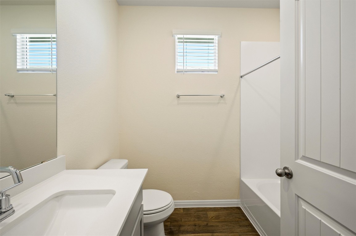 224 Kickapoo Lane Kyle, TX 78640 - Photo 18 of 31 Bathroom featuring vanity, dark wood-style flooring, and bathtub / shower combination