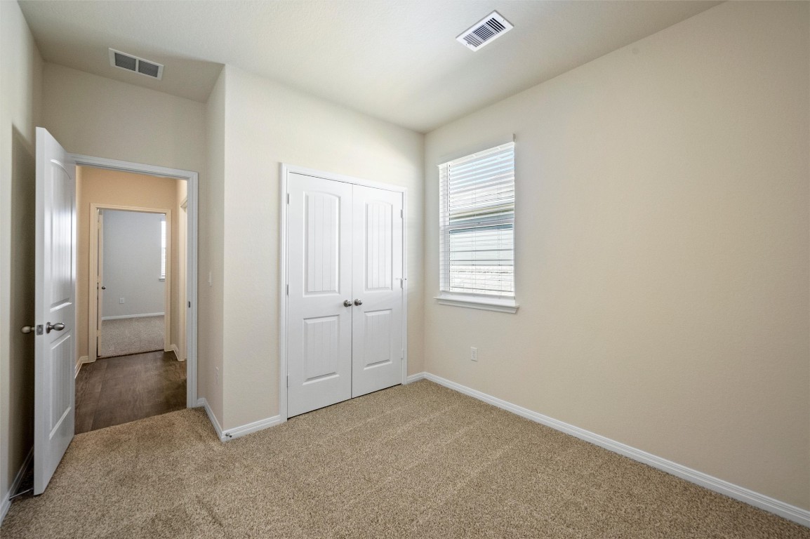 224 Kickapoo Lane Kyle, TX 78640 - Photo 20 of 31 Unfurnished bedroom with carpet floors and a closet