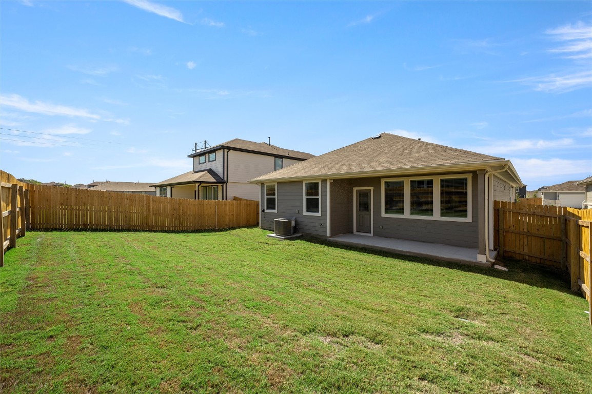 224 Kickapoo Lane Kyle, TX 78640 - Photo 25 of 31 Rear view of house featuring a patio area, a fenced backyard, and roof with shingles