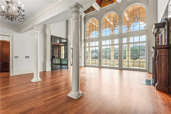 a view of an empty room with wooden floor and a fireplace