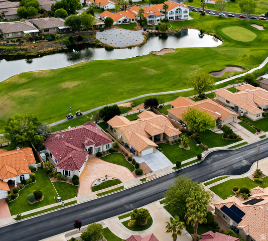 1985 West Rivers Edge Lane St. George, UT 84770 - Photo 1 of 42 Aerial view of property and surrounding area featuring nearby suburban area, a golf course, and a large body of water