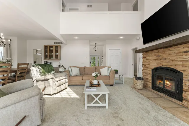 a kitchen with stainless steel appliances granite countertop a sink a stove a refrigerator and white cabinets