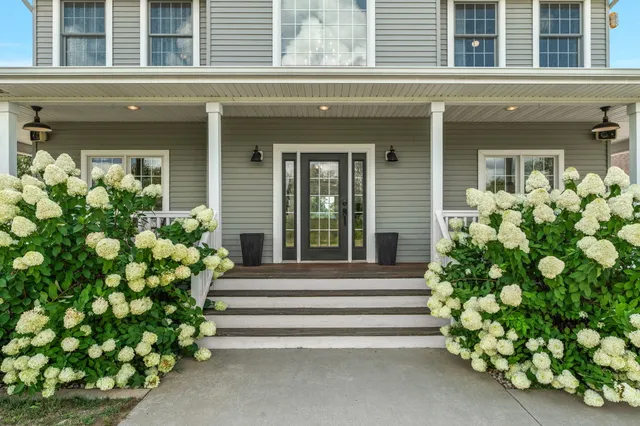 a view of a house next to a big yard with large trees