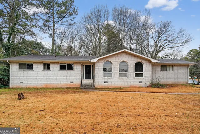 a large white house with a big yard and large trees