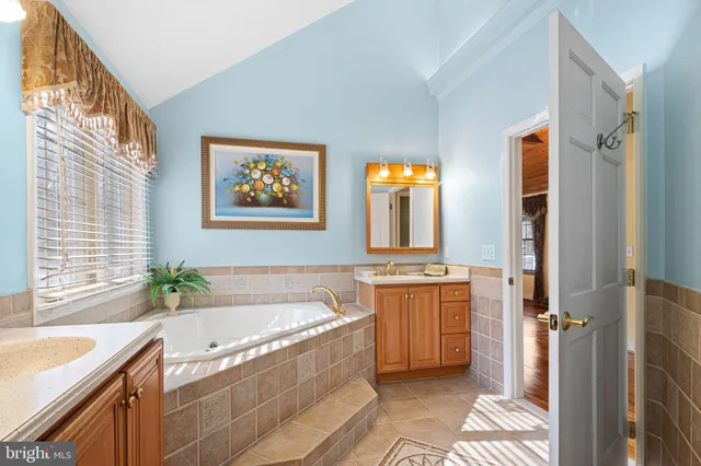 a spacious bathroom with a granite countertop tub sink and mirror