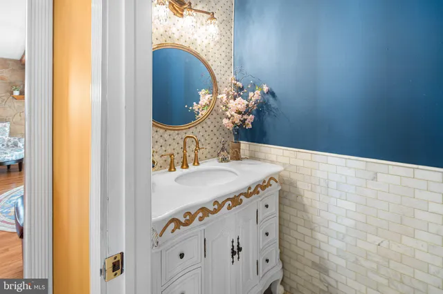 a bathroom with a granite countertop sink and a mirror