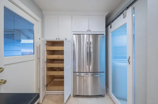 a view of kitchen with refrigerator and cabinet