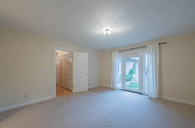 an empty room with closet and windows