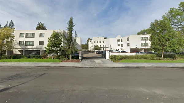 a view of a house with a garden and pathway