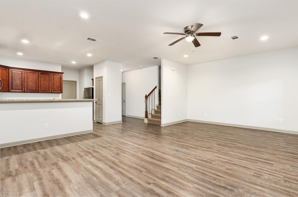 910 Shady Lane, Unit B Conroe, TX 77301 - Photo 11 of 18 a view of an empty room with wooden floor and a ceiling fan