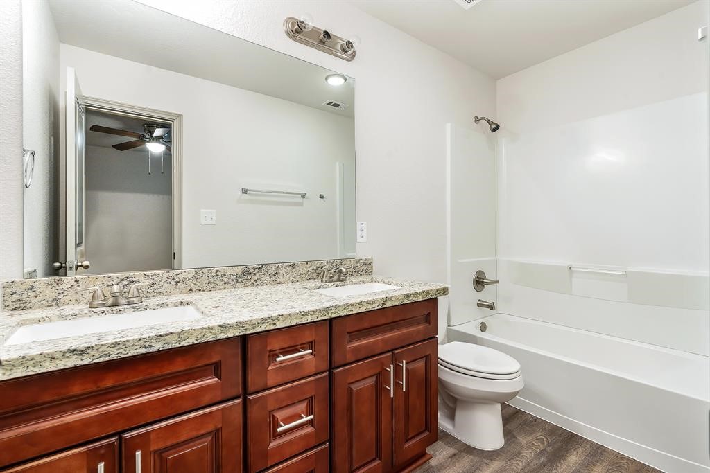 910 Shady Lane, Unit B Conroe, TX 77301 - Photo 14 of 18 a bathroom with a granite countertop sink toilet and shower