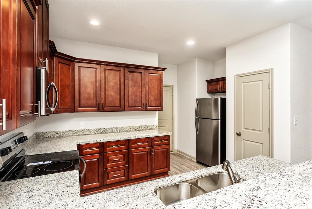 910 Shady Lane, Unit B Conroe, TX 77301 - Photo 7 of 18 a kitchen with a refrigerator and a sink
