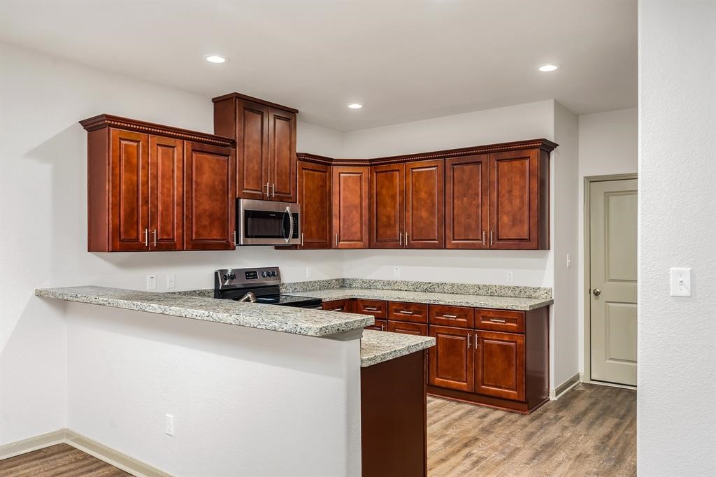 910 Shady Lane, Unit B Conroe, TX 77301 - Photo 8 of 18 a kitchen with stainless steel appliances granite countertop a stove a sink and a microwave
