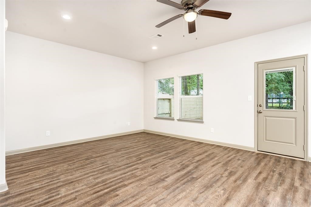 910 Shady Lane, Unit B Conroe, TX 77301 - Photo 10 of 18 wooden floor in an empty room with a window