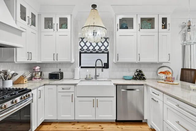 a kitchen with white cabinets and appliances
