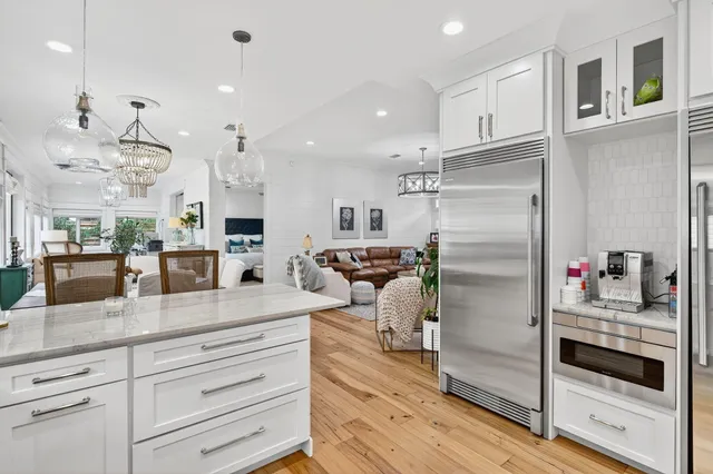a kitchen with stainless steel appliances kitchen island granite countertop a refrigerator and a sink